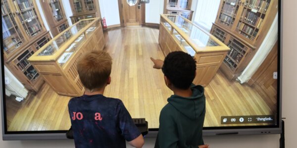 two school pupils using an interactive screen